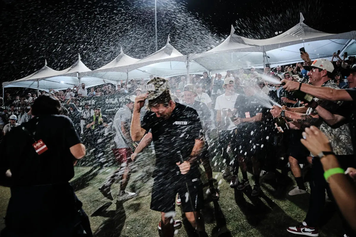 Phoenix United team celebrates with a champagne spray on the green